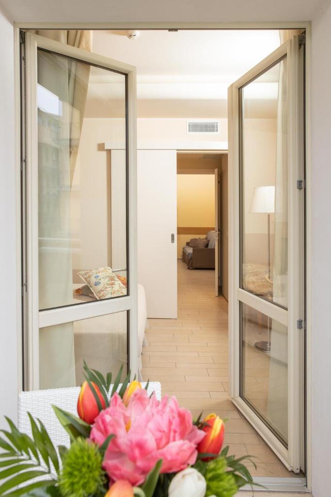 Cette chambre comprend des miroirs et une table avec des fleurs. dans l'établissement Relais Concorde, à Grottammare