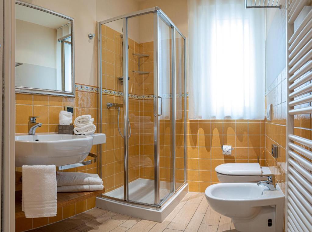 une salle de bain avec une douche, des toilettes et un lavabo dans l'établissement Relais Concorde, à Grottammare
