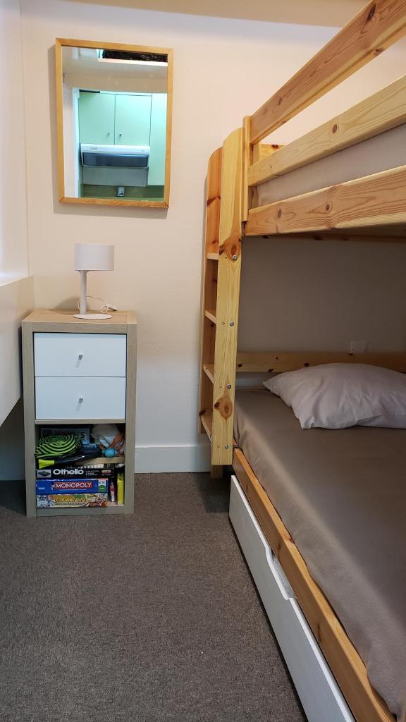 une chambre avec un lit superposé et un miroir dans l'établissement Balcon plein Sud sur les pistes, à Isola 2000