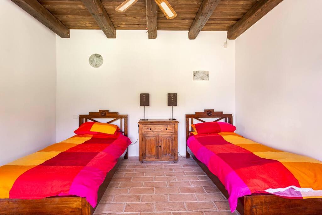 - 2 lits dans une chambre dotée de draps rouges et oranges dans l'établissement Luxury Villa with Pool, Stunning Location, à San Ginesio 35 autres photos