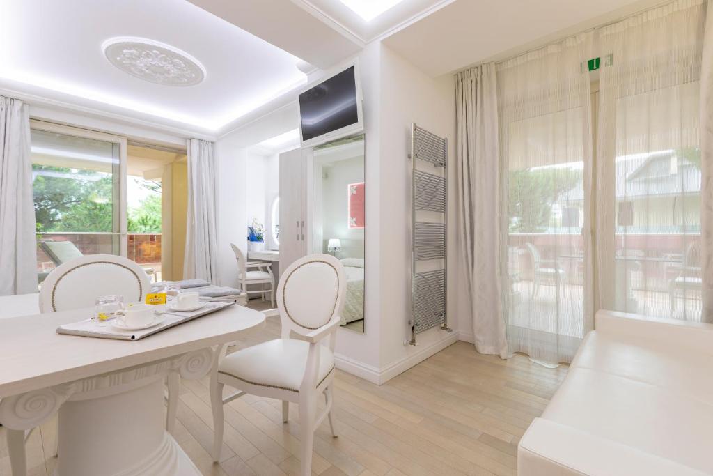 une salle à manger blanche avec une table et des chaises dans l'établissement Boutique Hotel Paradiso Bovelacci, à Milano Marittima