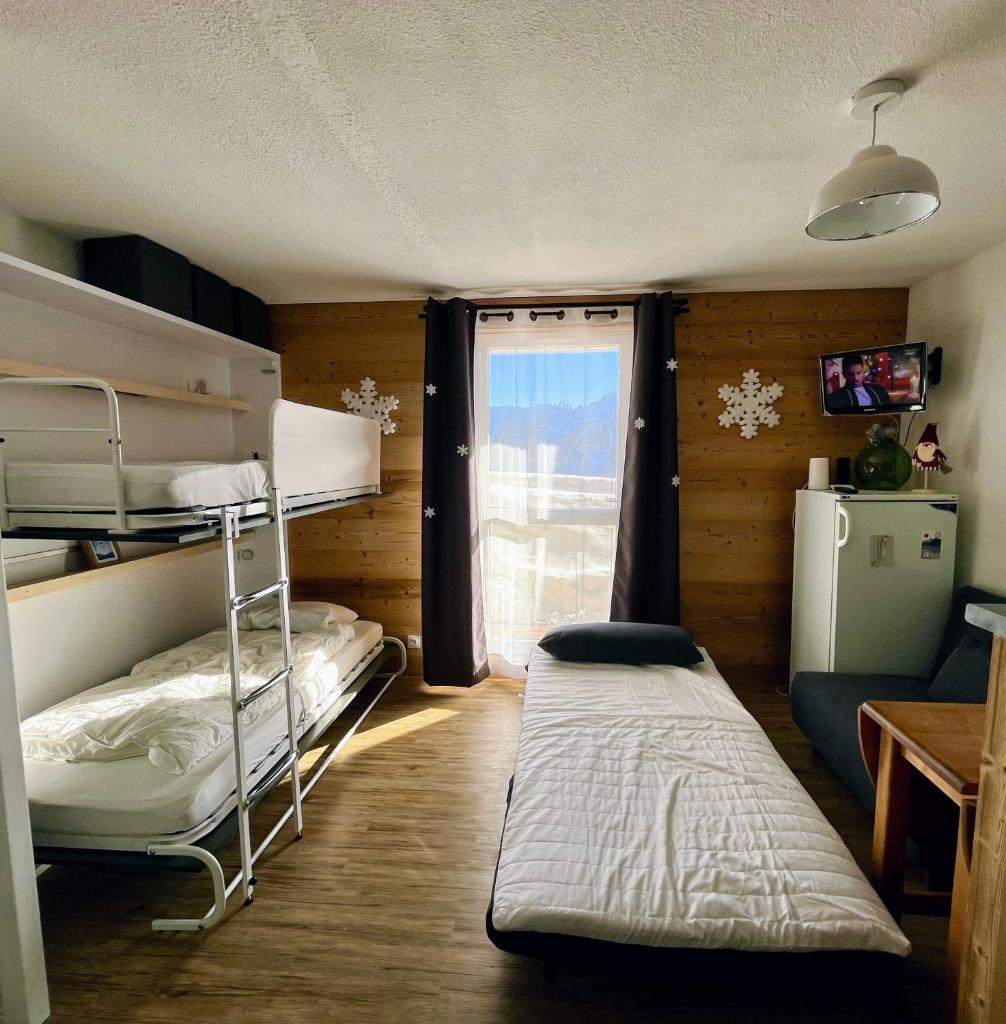 une chambre avec deux lits superposés et une fenêtre dans l'établissement Samoens 1600, ski au pied, à Samoëns