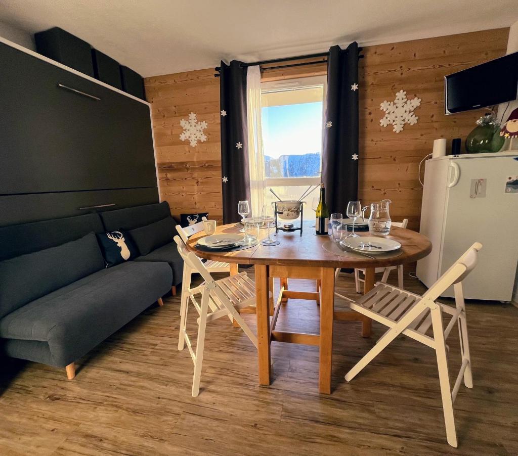 une salle à manger avec une table et un canapé dans l'établissement Samoens 1600, ski au pied, à Samoëns