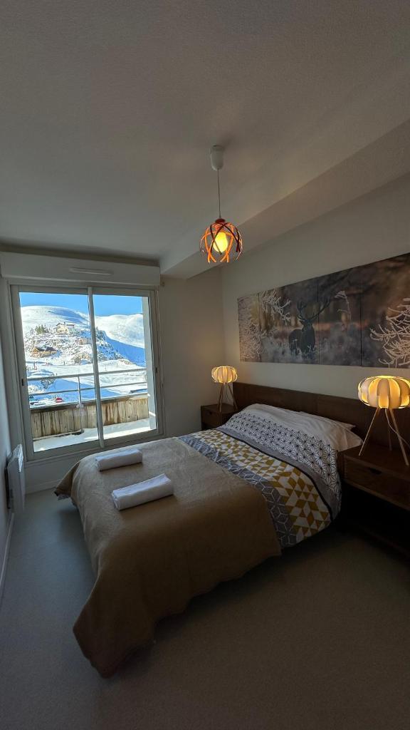 une chambre avec un grand lit et une grande fenêtre dans l'établissement Appartements du Pic d'Anie, à Arette 34 autres photos