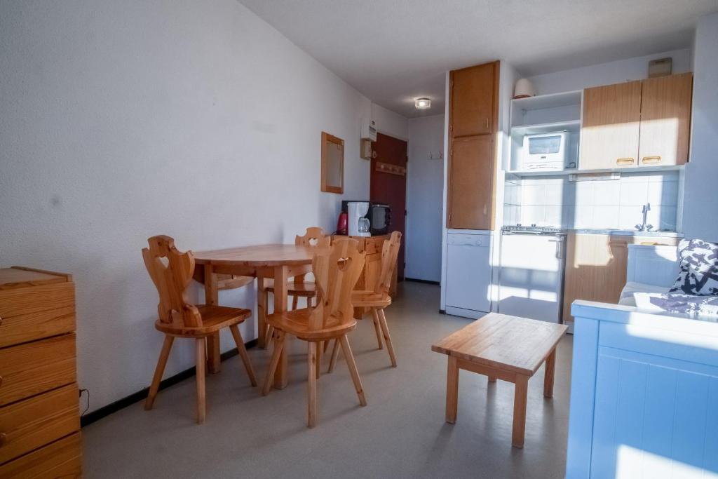 une cuisine avec une table et des chaises dans une pièce dans l'établissement Appartement Aldeïa - Welkeys, à Huez