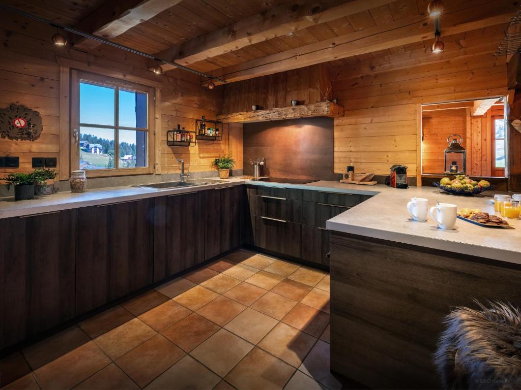 - une grande cuisine avec des murs en bois et des comptoirs en bois dans l'établissement Chalet Capieu - Le Barn - OVO Network, à Manigod