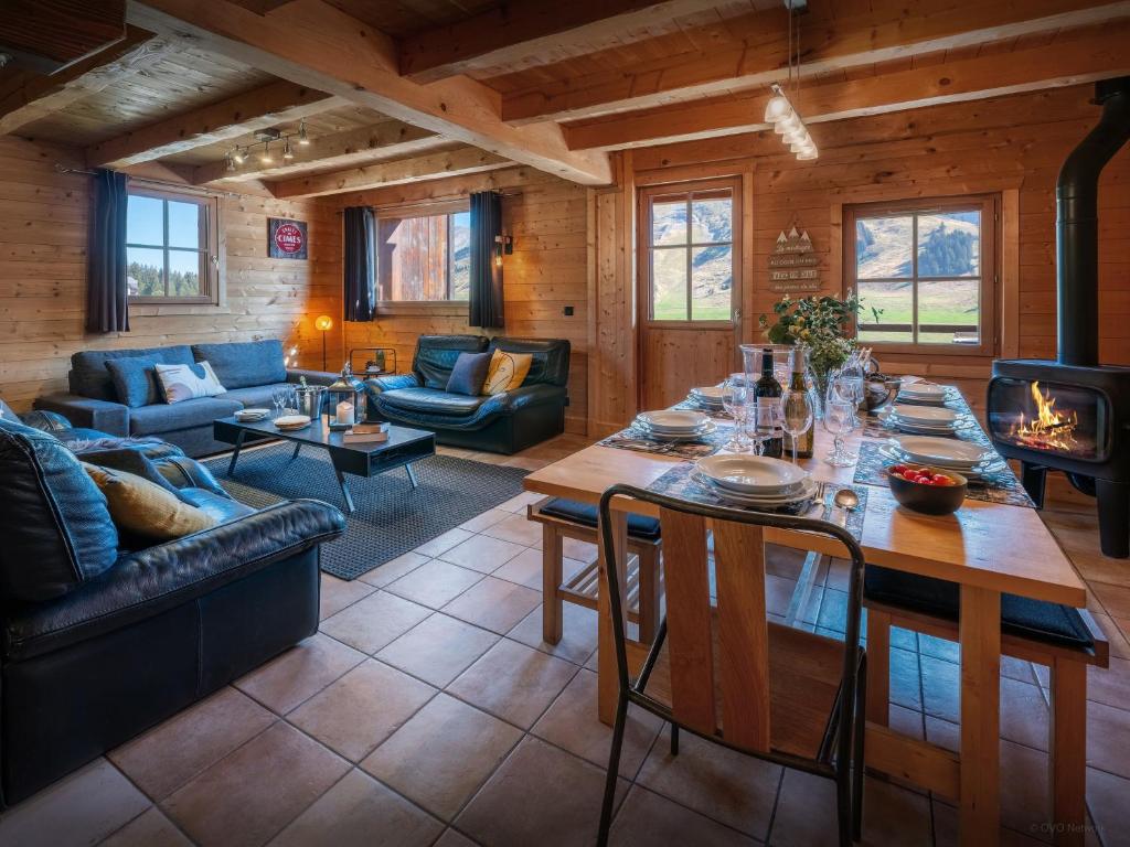 un salon avec une table et une cheminée dans l'établissement Chalet Capieu - Le Barn - OVO Network, à Manigod