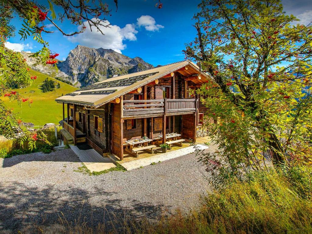 une cabane en rondins avec des montagnes en arrière-plan dans l'établissement Chalet Capieu - Le Barn - OVO Network, à Manigod