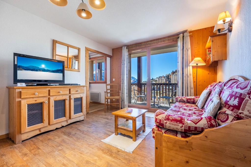 un salon avec un canapé et une télévision à écran plat dans l'établissement Appartement 6 personnes - Deux chambres - 40M2 - Balcons 10M2 sur pistes - Aucun vis à vis - Piscine - B301, à Orcières