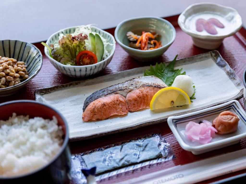une table avec une assiette de nourriture et des bols de nourriture dans l'établissement Tennenonsen Harunonoyu, à Kōchi