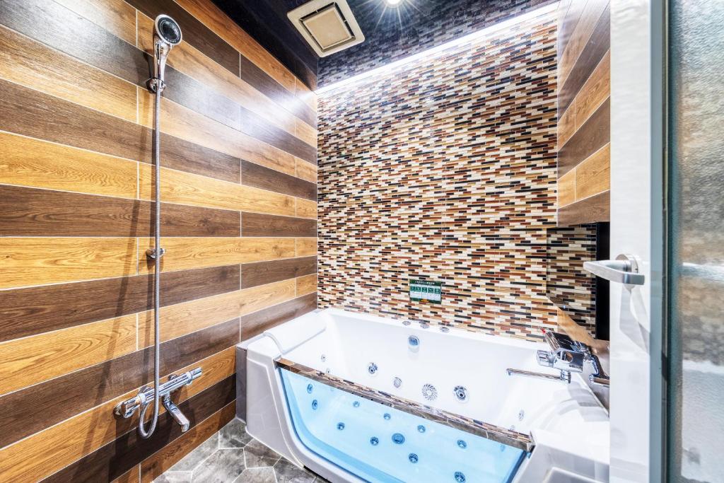 une salle de bain avec baignoire et douche dans l'établissement Hotel Artia Dinosaur hirakata -Adult Only, à Hirakata