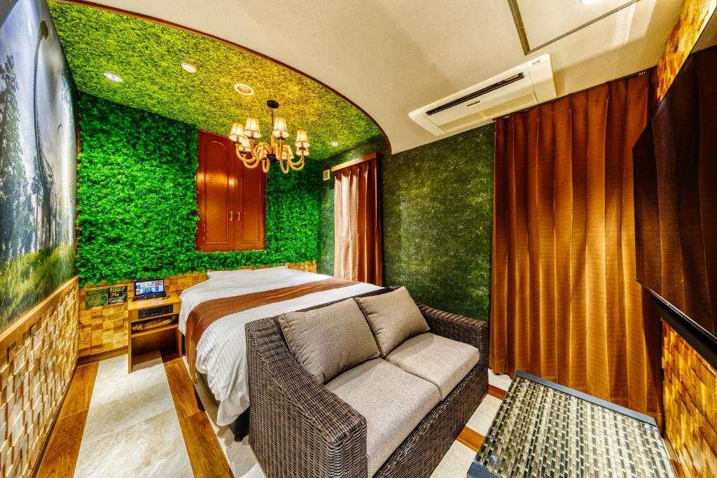 - une chambre dotée d'un mur vert avec un lit et un canapé dans l'établissement Hotel Artia Dinosaur hirakata -Adult Only, à Hirakata 10 autres photos