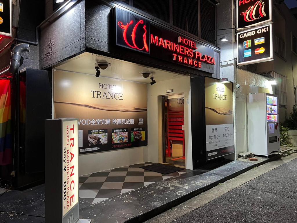 un restaurant avec des panneaux sur le côté d'un bâtiment dans l'établissement トランス 神戸三宮男塾ホテルグループ, à Kobe
