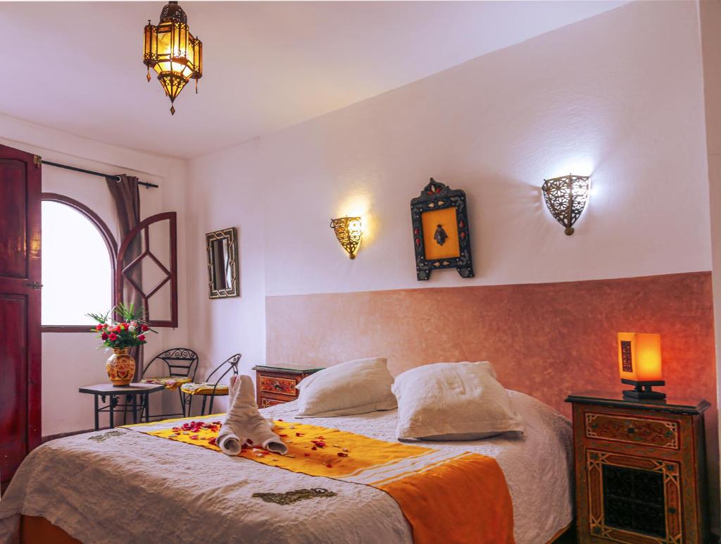 une chambre avec un lit avec un animal en peluche dessus dans l'établissement Dar Nafoura-Mogador, à Essaouira
