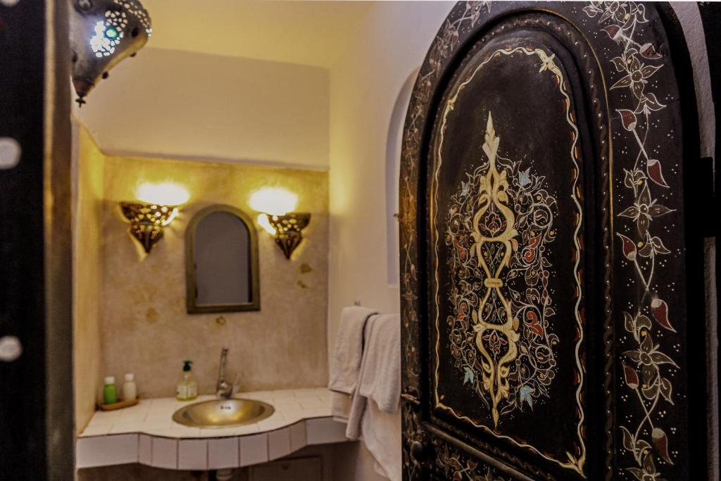 une salle de bain avec un lavabo et un miroir dans l'établissement Dar Nafoura-Mogador, à Essaouira