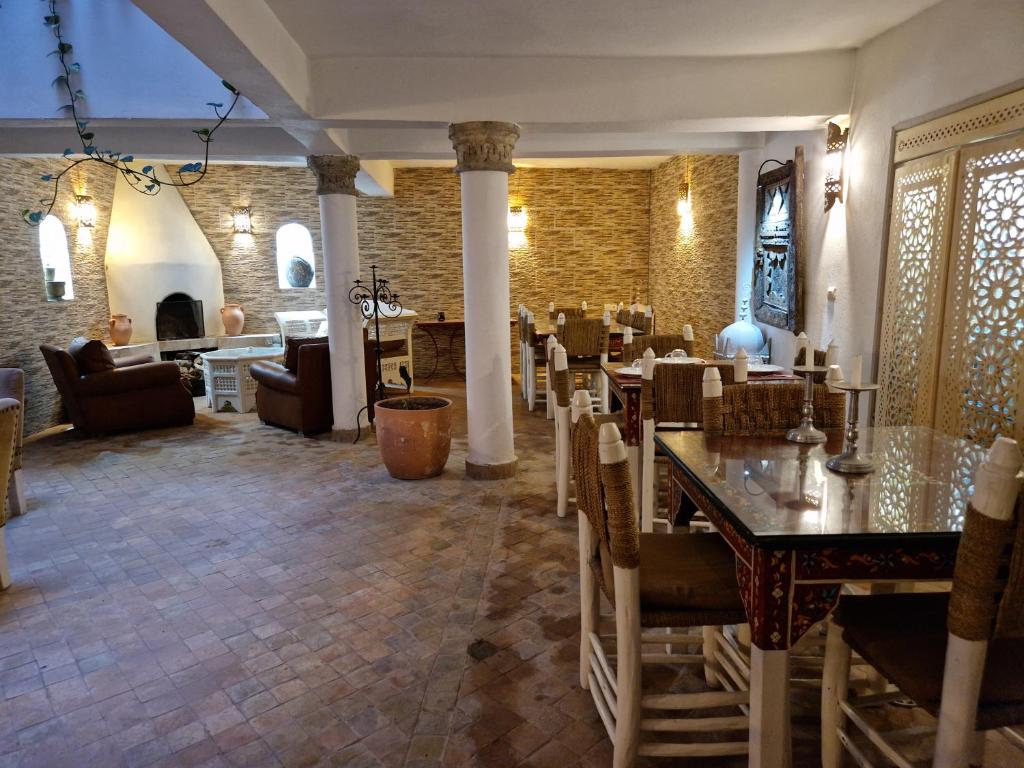 un restaurant avec des tables et des chaises dans une salle dans l'établissement Dar Nafoura-Mogador, à Essaouira