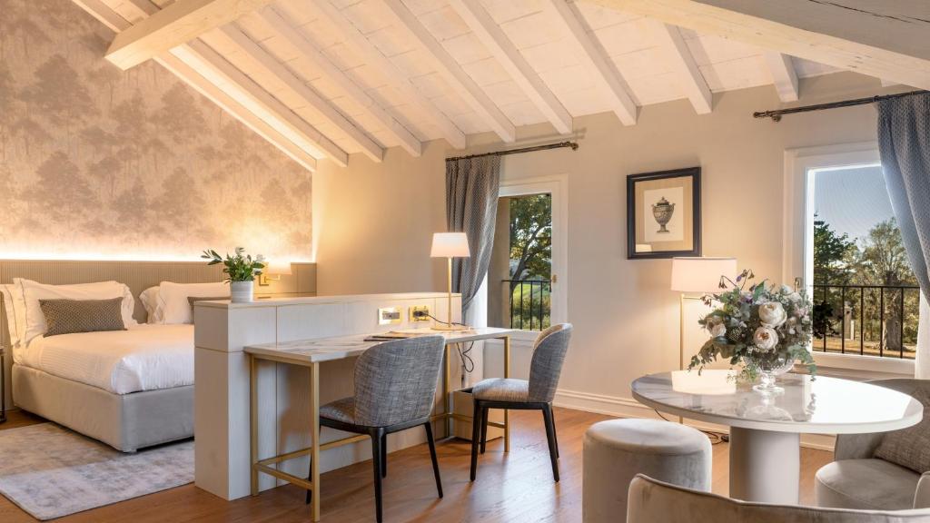 une chambre avec un lit, un bureau et des chaises dans l'établissement SANTA MARIA MADDALENA 10, Emma Villas, à Castel San Pietro Terme 43 autres photos