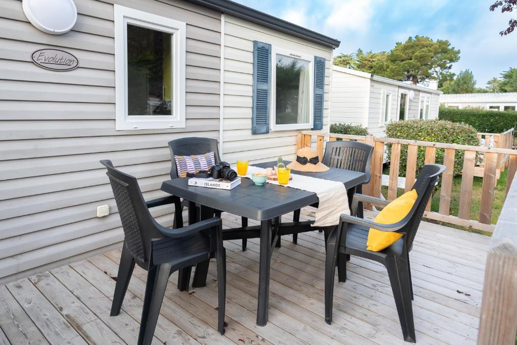 un patio avec une table et des chaises sur une terrasse dans l'établissement Bontempo Village camping 4 étoiles, à Piriac-sur-Mer