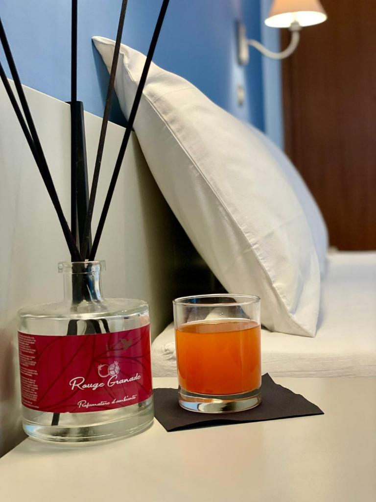 une boisson dans une bouteille à côté d'un vase sur une table dans l'établissement Hotel Alfa - SPIAGGIA INCLUSA con Formula All Inclusive, à Rimini