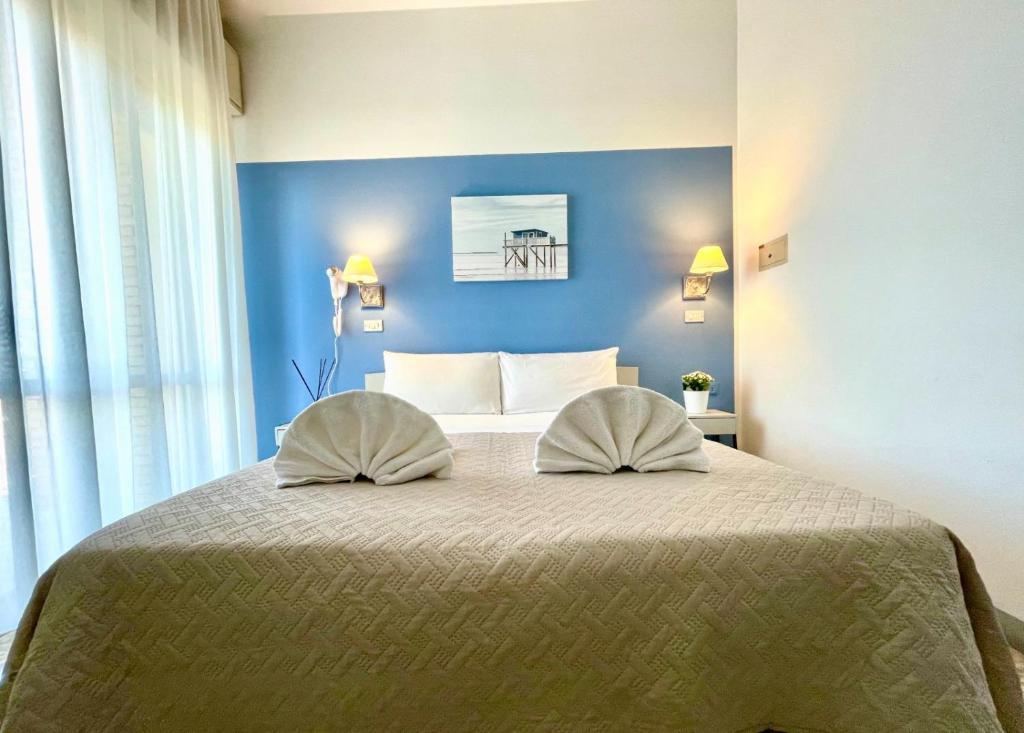 une chambre avec un lit avec deux oreillers dessus dans l'établissement Hotel Alfa - SPIAGGIA INCLUSA con Formula All Inclusive, à Rimini 63 autres photos