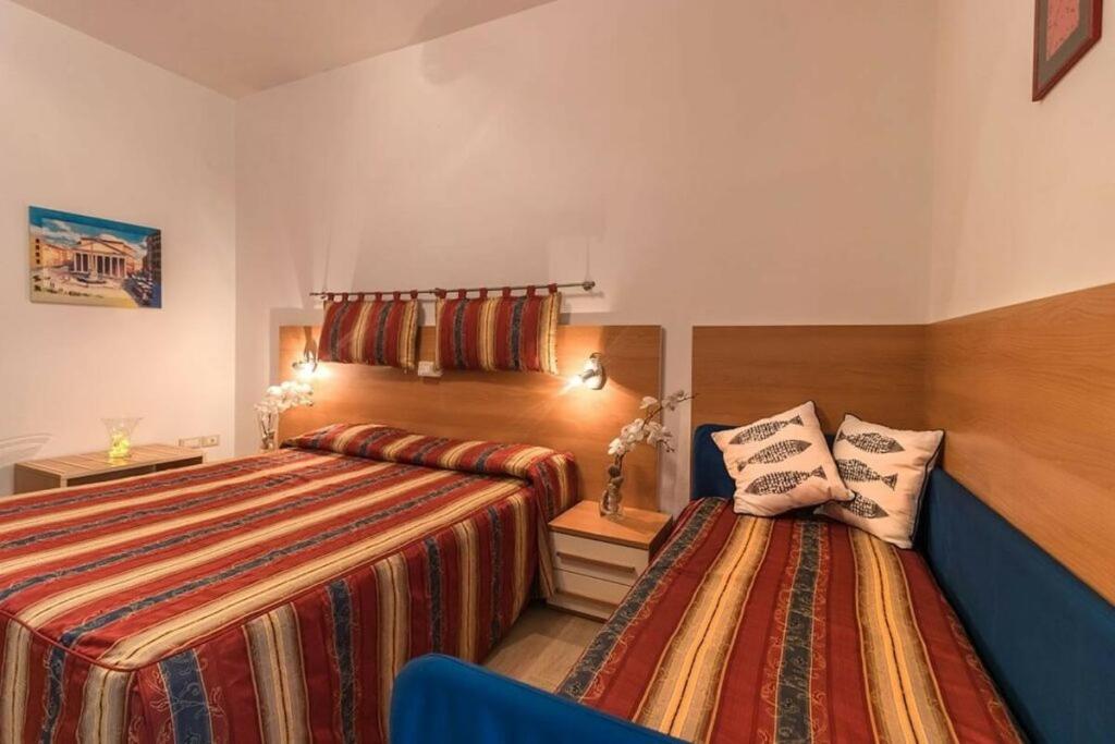 une chambre avec deux lits et un canapé bleu dans l'établissement Hotel Corallo, à Giulianova