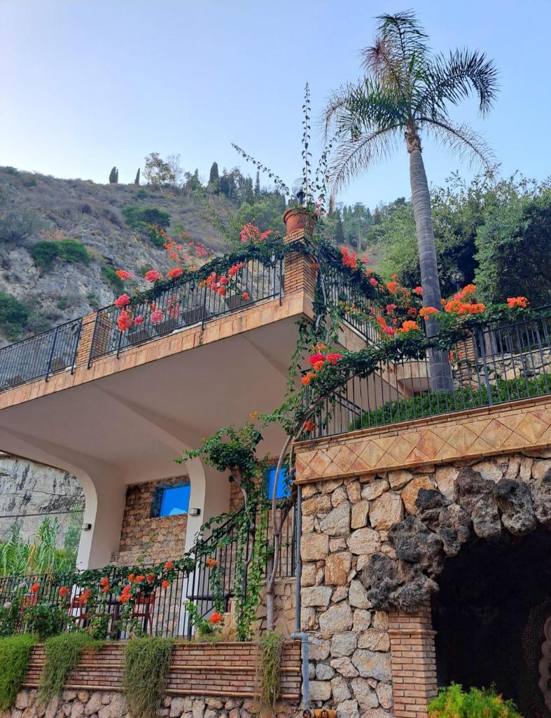 un bâtiment avec un balcon fleuri dans l'établissement Hotel Corallo, à Taormine