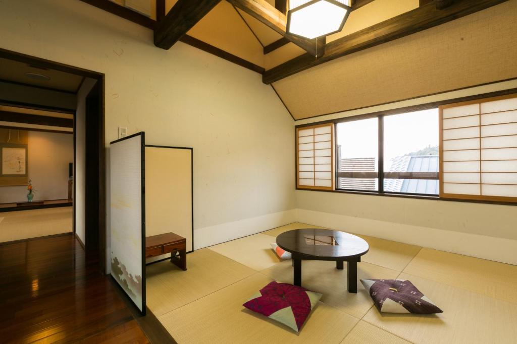 une pièce avec une table dans une pièce avec des fenêtres dans l'établissement Kotonoyado Musashino, à Nara