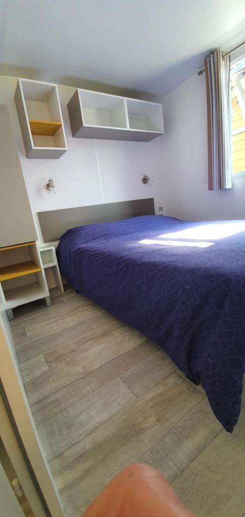 - une chambre avec un lit violet et du parquet dans l'établissement Mobil home sur Camping, à Saint-Jean-de-la-Rivière