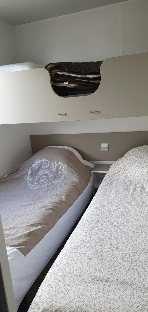 une chambre avec deux lits dans une pièce dans l'établissement Mobil home sur Camping, à Saint-Jean-de-la-Rivière