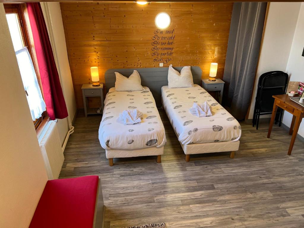 - deux lits dans une chambre avec deux tables et des chaises dans l'établissement La Foret De Maronne, à La Garde