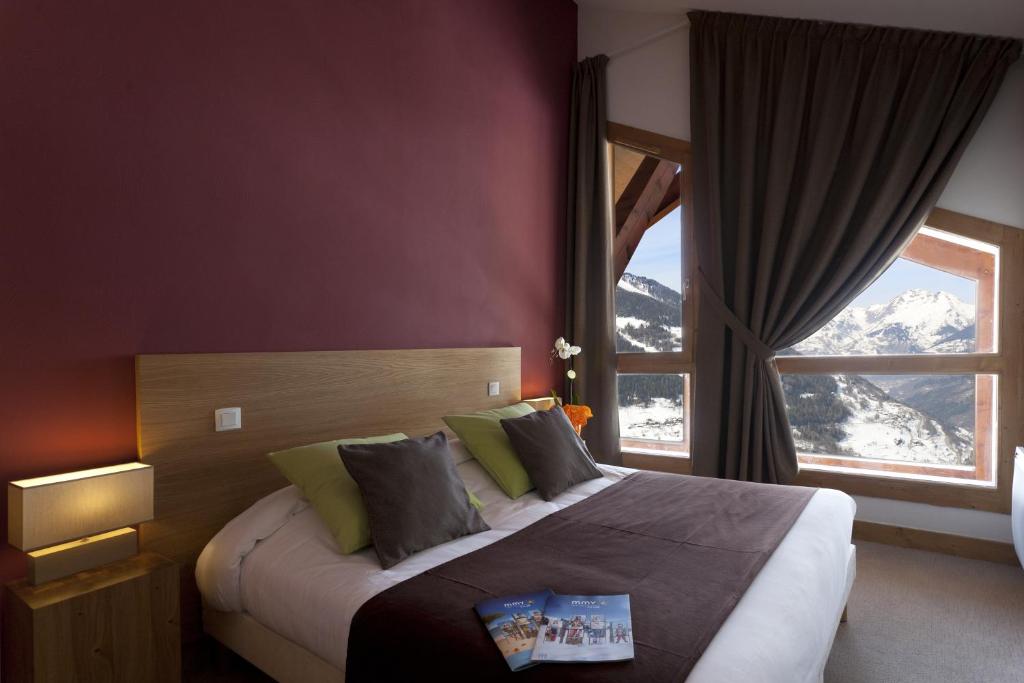 une chambre avec un grand lit avec une grande fenêtre dans l'établissement Résidence Club mmv L'Étoile des Cimes ****, à Sainte-Foy-Tarentaise 37 autres photos