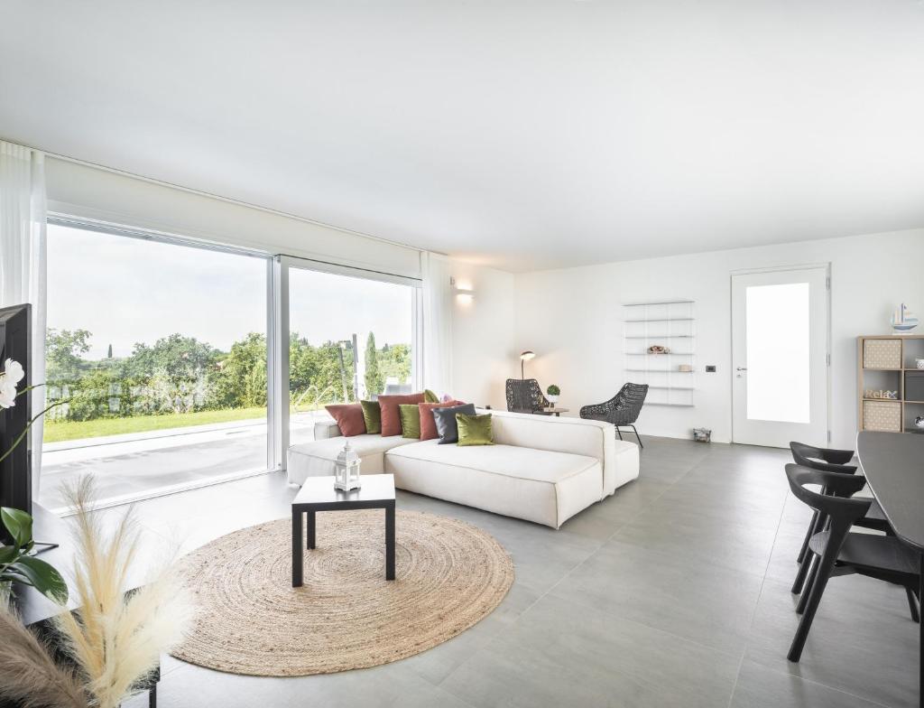 un salon avec un canapé blanc et une table dans l'établissement Villa Angelina, à Lazise