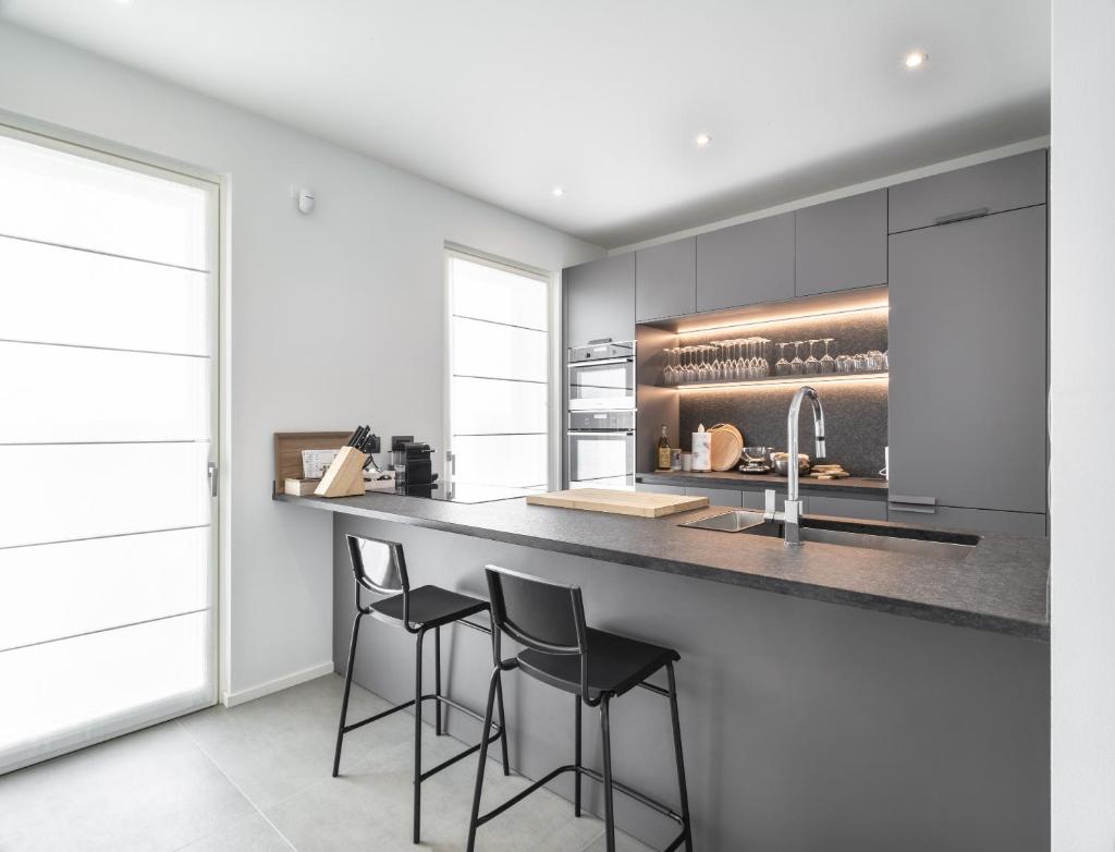 une cuisine avec tabourets noirs à un comptoir dans l'établissement Villa Angelina, à Lazise