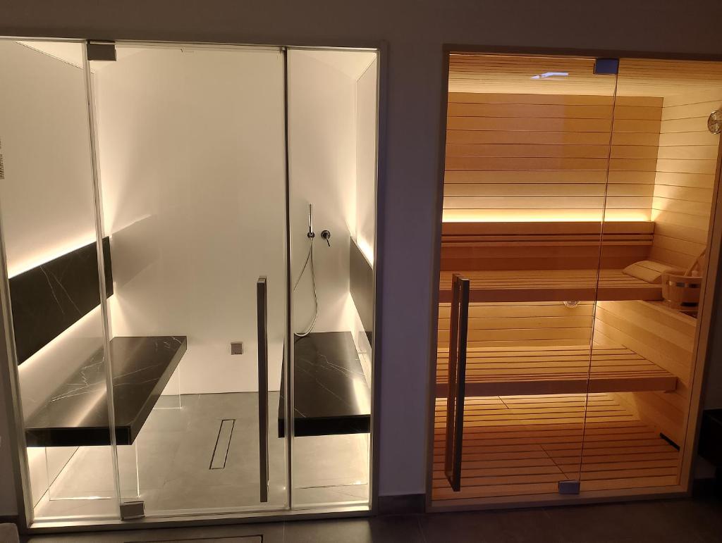 - un sauna avec une porte en verre dans la pièce dans l'établissement Ville dell'Eden con 9 camere da letto in 6 unità abitative, à Lascari
