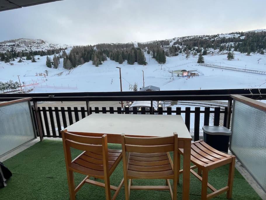 d'une table et de deux chaises sur un balcon avec une piste de ski. dans l'établissement Moment magique aux pieds des pistes à Superdevoluy, à Saint-Étienne-en-Dévoluy