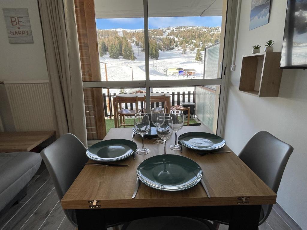 - une table en bois avec des verres et des assiettes dans l'établissement Moment magique aux pieds des pistes à Superdevoluy, à Saint-Étienne-en-Dévoluy