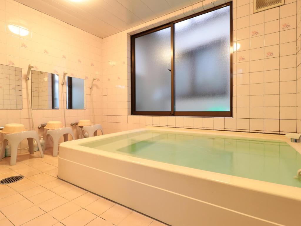 une grande salle de bains avec une grande baignoire. dans l'établissement Business Ryokan Iroha, à Minokamo