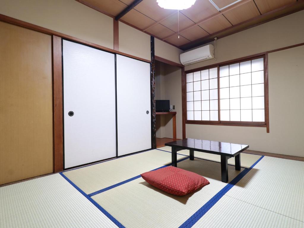 Cette chambre comprend une table et une fenêtre. dans l'établissement Business Ryokan Iroha, à Minokamo