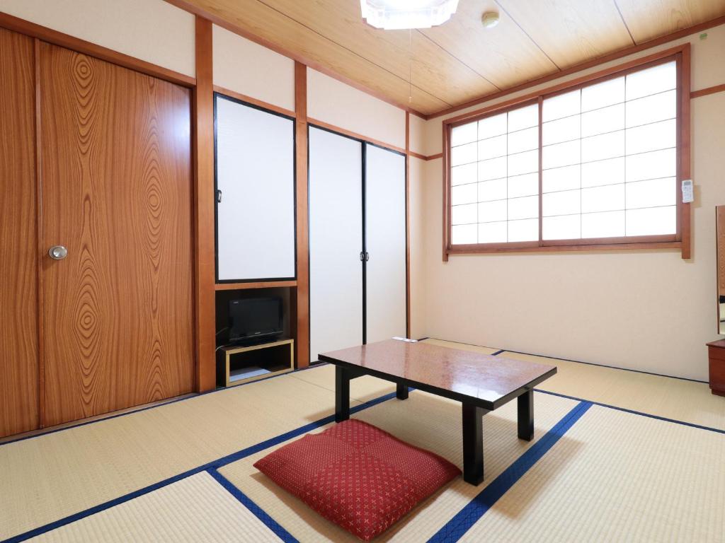 Cette chambre dispose d'une table, d'une télévision et de fenêtres. dans l'établissement Business Ryokan Iroha, à Minokamo 34 autres photos