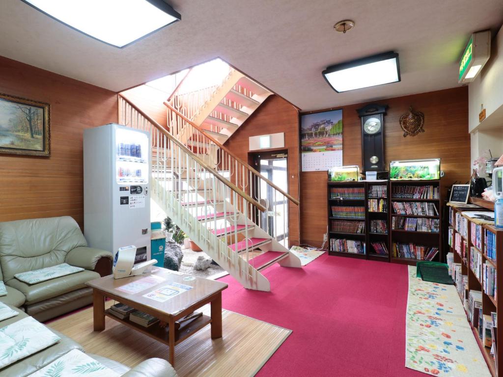 une bibliothèque avec un escalier en colimaçon et une étagère à livres dans l'établissement Business Ryokan Iroha, à Minokamo