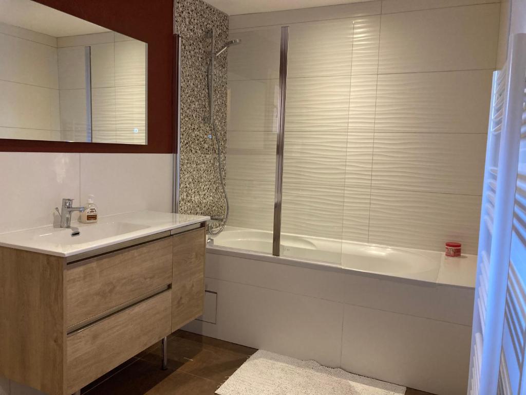 La salle de bains est pourvue d'une baignoire, d'un lavabo et d'une baignoire. dans l'établissement Renovated flat facing Mont Blanc, à Combloux 33 autres photos
