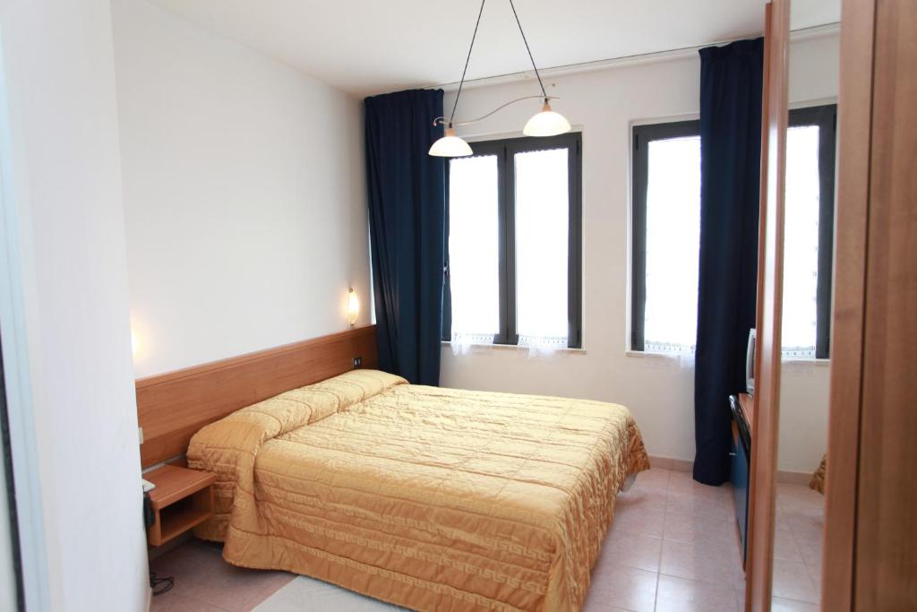 une chambre avec deux lits et deux fenêtres dans l'établissement Hotel Athena, à Pesaro