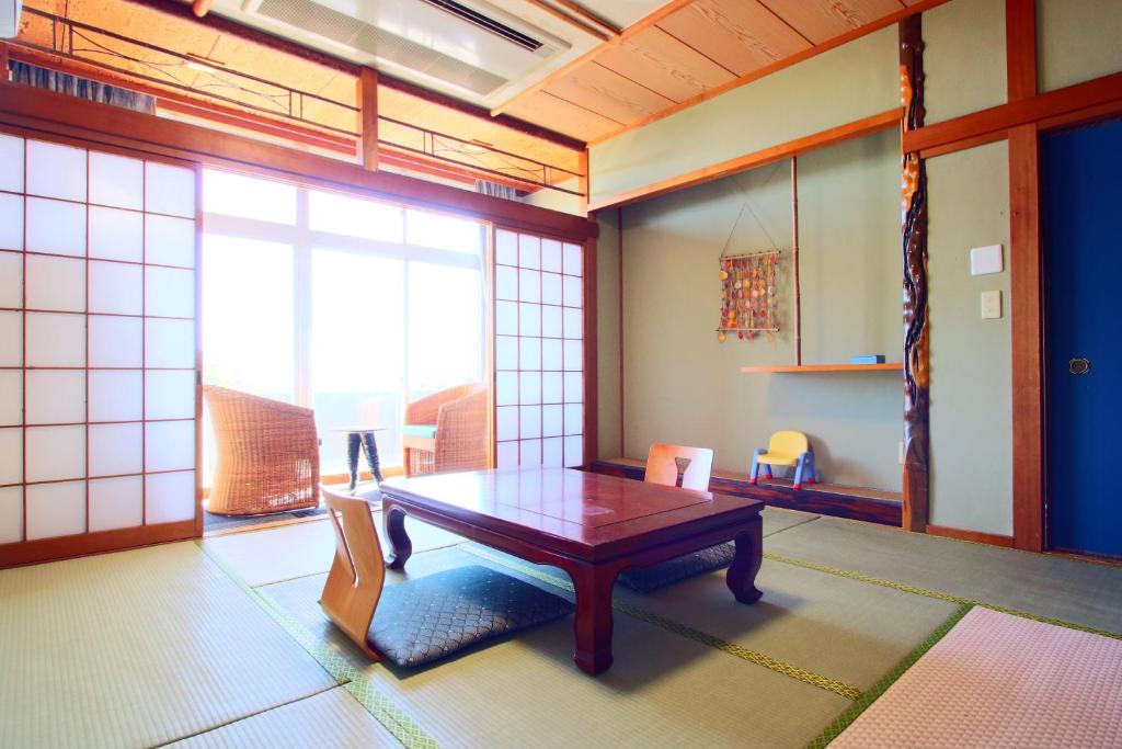 une pièce avec une table et des chaises dans une pièce dans l'établissement Hanayukaku, à Shima