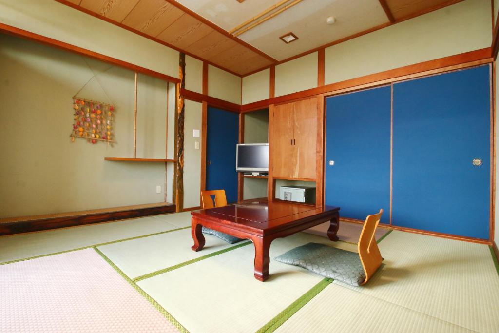 - un salon avec une table en bois et une télévision dans l'établissement Hanayukaku, à Shima