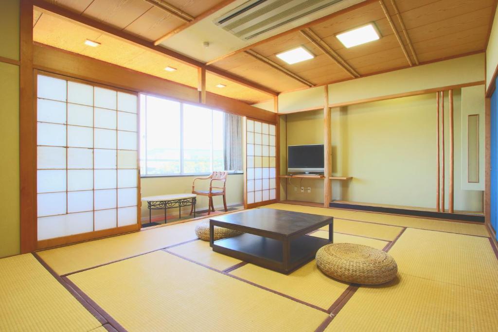 Cette grande chambre dispose d'une table et d'une télévision. dans l'établissement Hanayukaku, à Shima