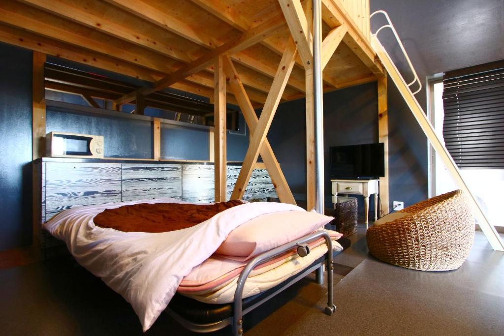 un lit dans une chambre avec un plafond en bois dans l'établissement Hanayukaku, à Shima