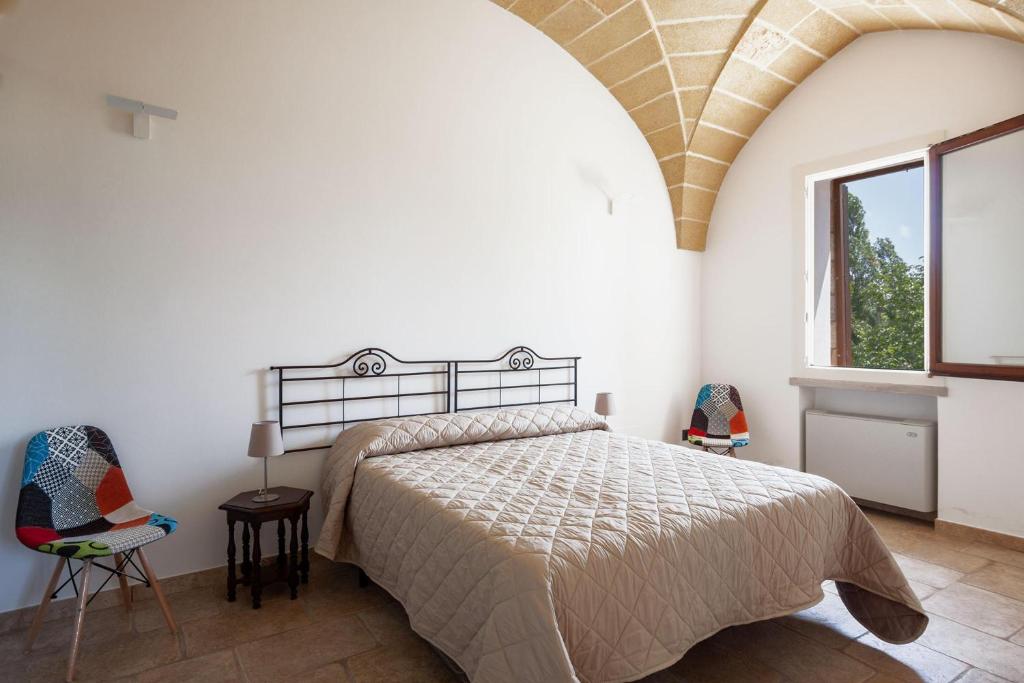 une chambre avec un lit et deux chaises et une fenêtre dans l'établissement Villa Salentina With Garden And Pool - Happy Rentals, à Santa Cesarea Terme