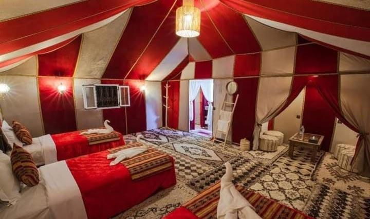 une chambre avec deux lits dans une tente dans l'établissement GITE Take your time, à Merzouga