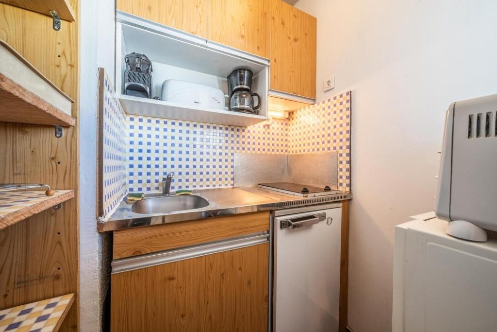 Elle comprend une petite cuisine avec des placards en bois et un évier. dans l'établissement Giffre, à Samoëns