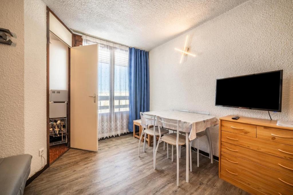 Cette chambre dispose d'une télévision et d'une table avec des chaises. dans l'établissement Giffre, à Samoëns